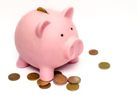 a pink piggy bank with coins