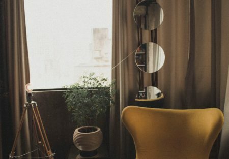 a room with a chair and a lamp and a window