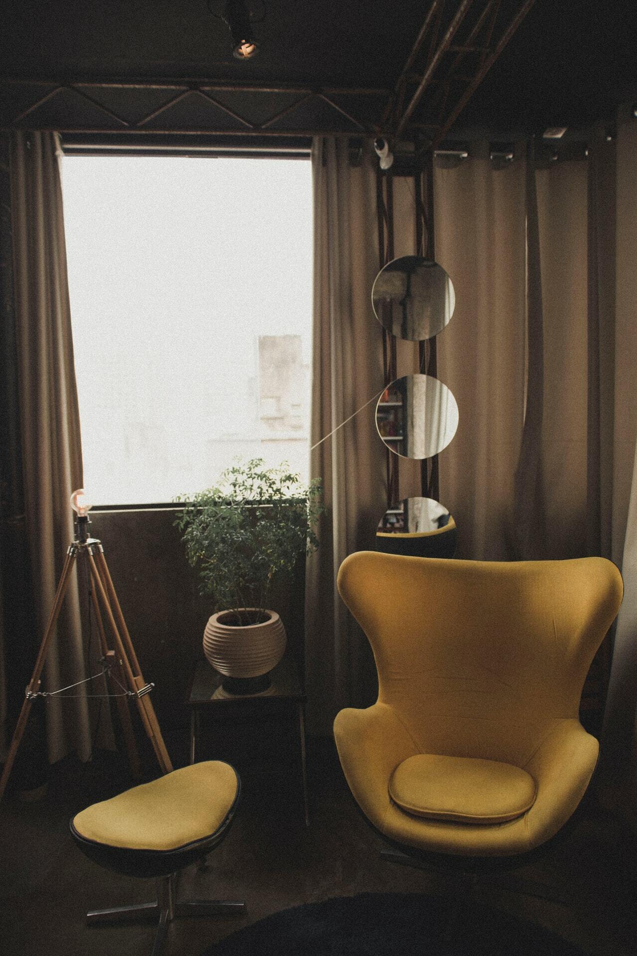 a room with a chair and a lamp and a window