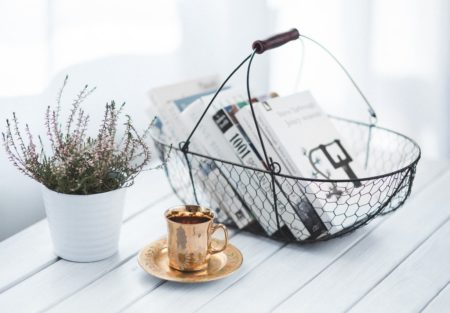 a scale with a cup of coffee and a plant