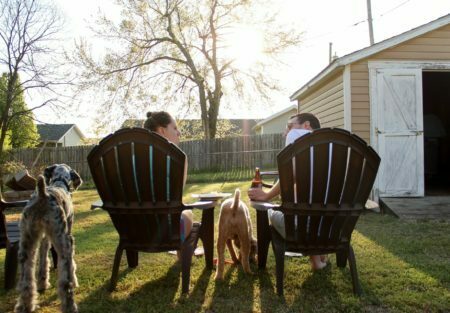 a person sitting in a chair with a group of dogs around him