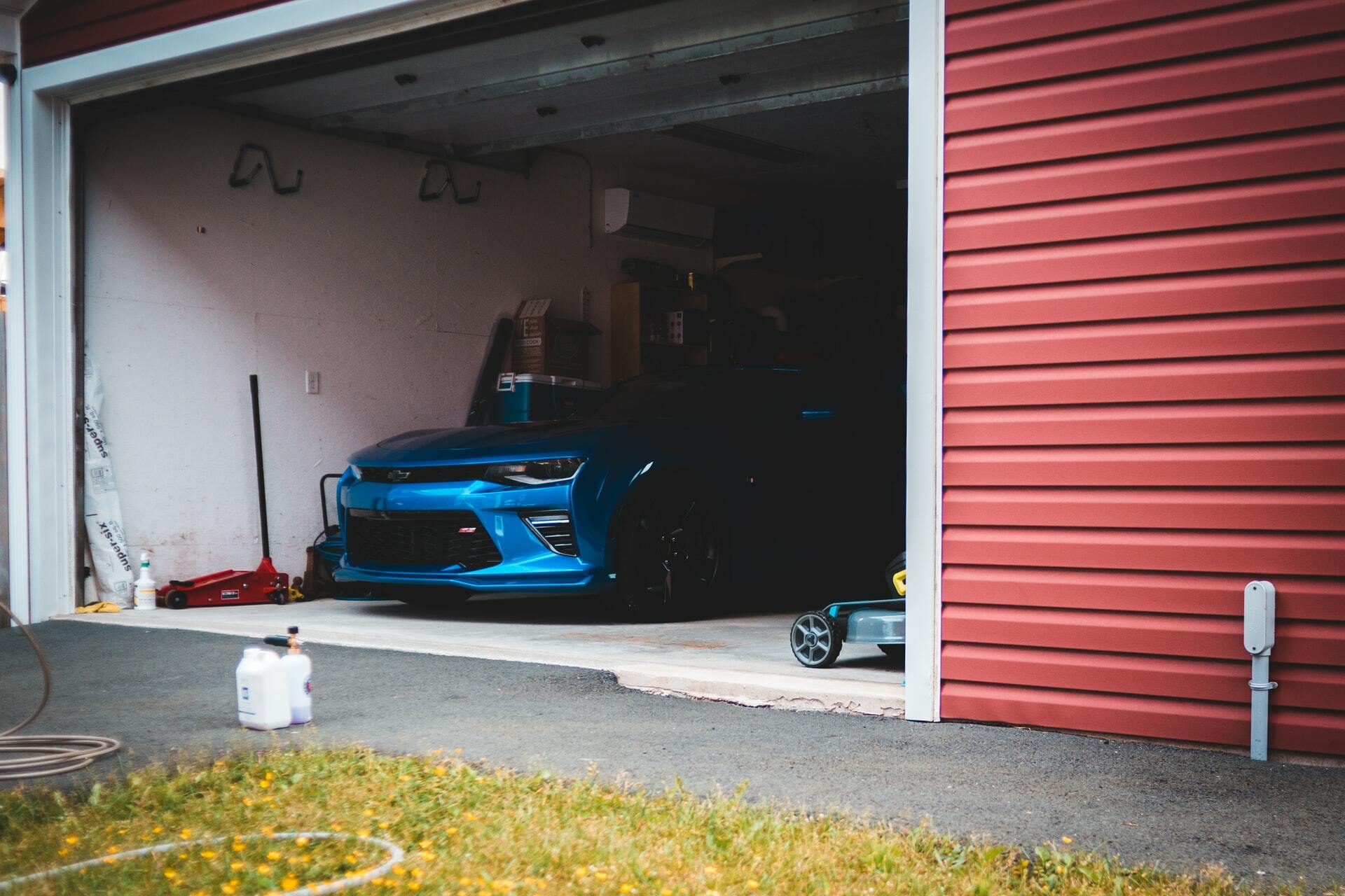 a garage door open with a blue car parked in the garage
