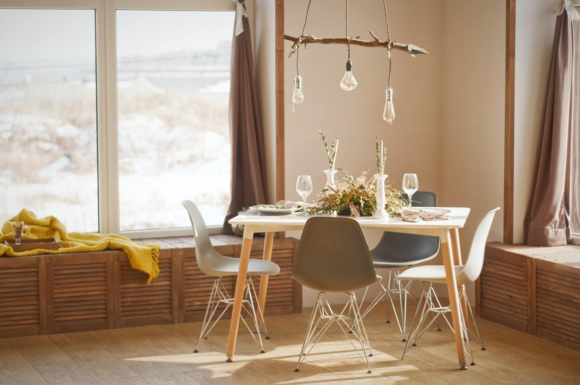 a dining table and chairs in a room with a window