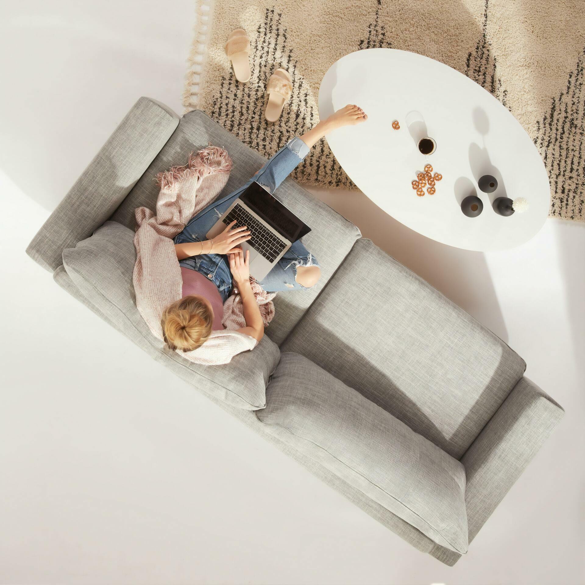 a man and woman sitting on a couch with a laptop