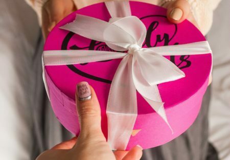 a person holding a pink and white umbrella